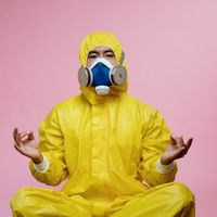 image humoristique d'un homme assis en tailleur en combinaison jaune avec un masque à gaz illustrant la respiration et relaxation en thérapie cognitive et comportementale tcc